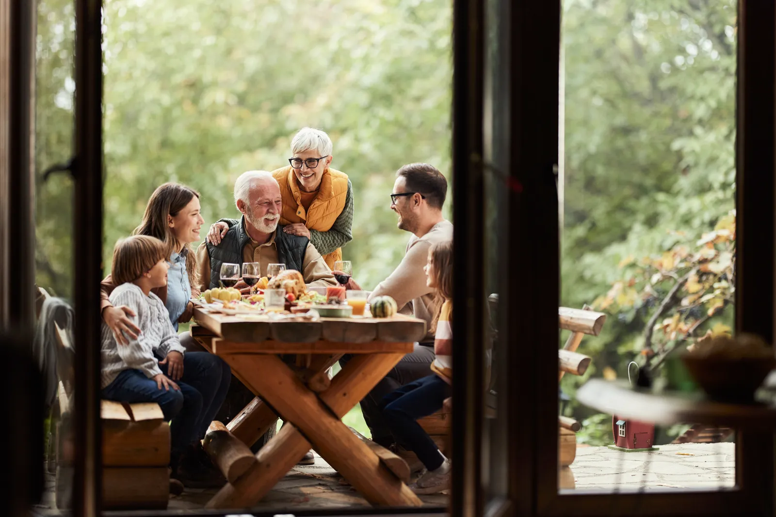 Three generations of a family sharing a meal at an outdoor table