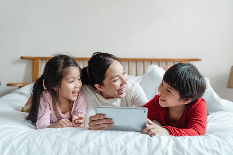 kids looking at iPad with mother, smiling looking at My First Nest Egg App 