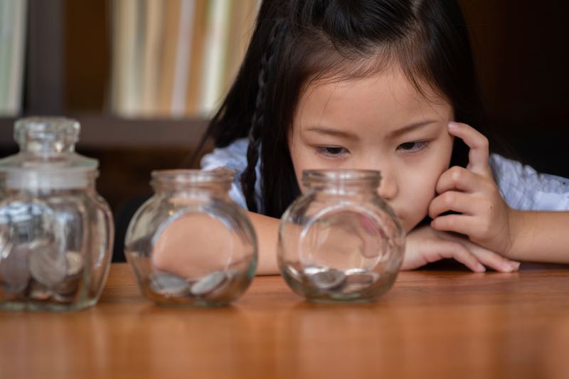 Young girl thinking about saving money and budgeting.