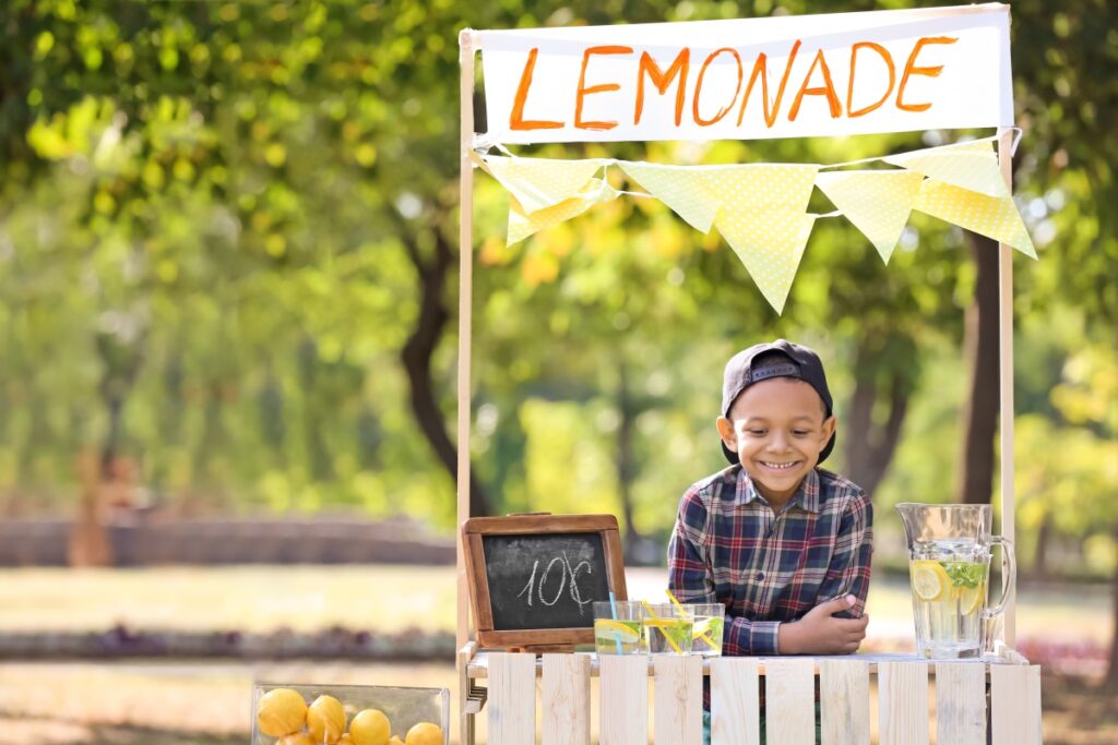 Kid selling lemonade at a home-made lemonade stand