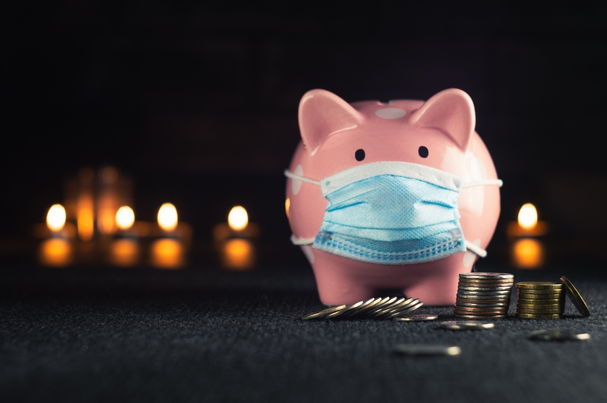Pink Piggy Bank with Mask on, Coins in front of piggy bank.