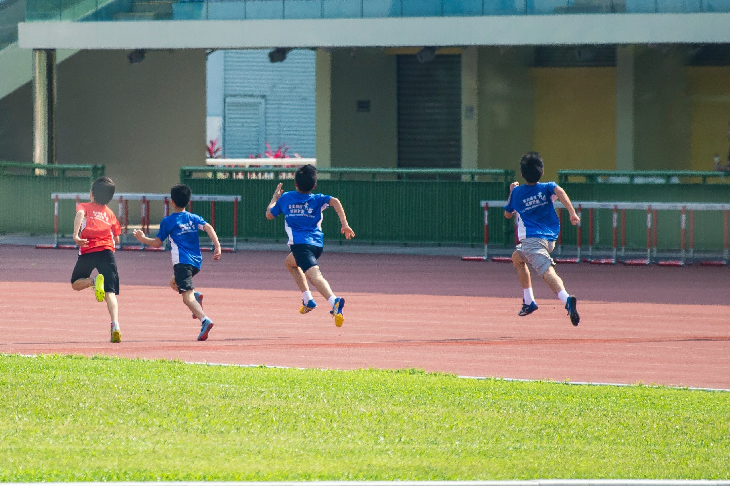 Four boys runing in a track race.