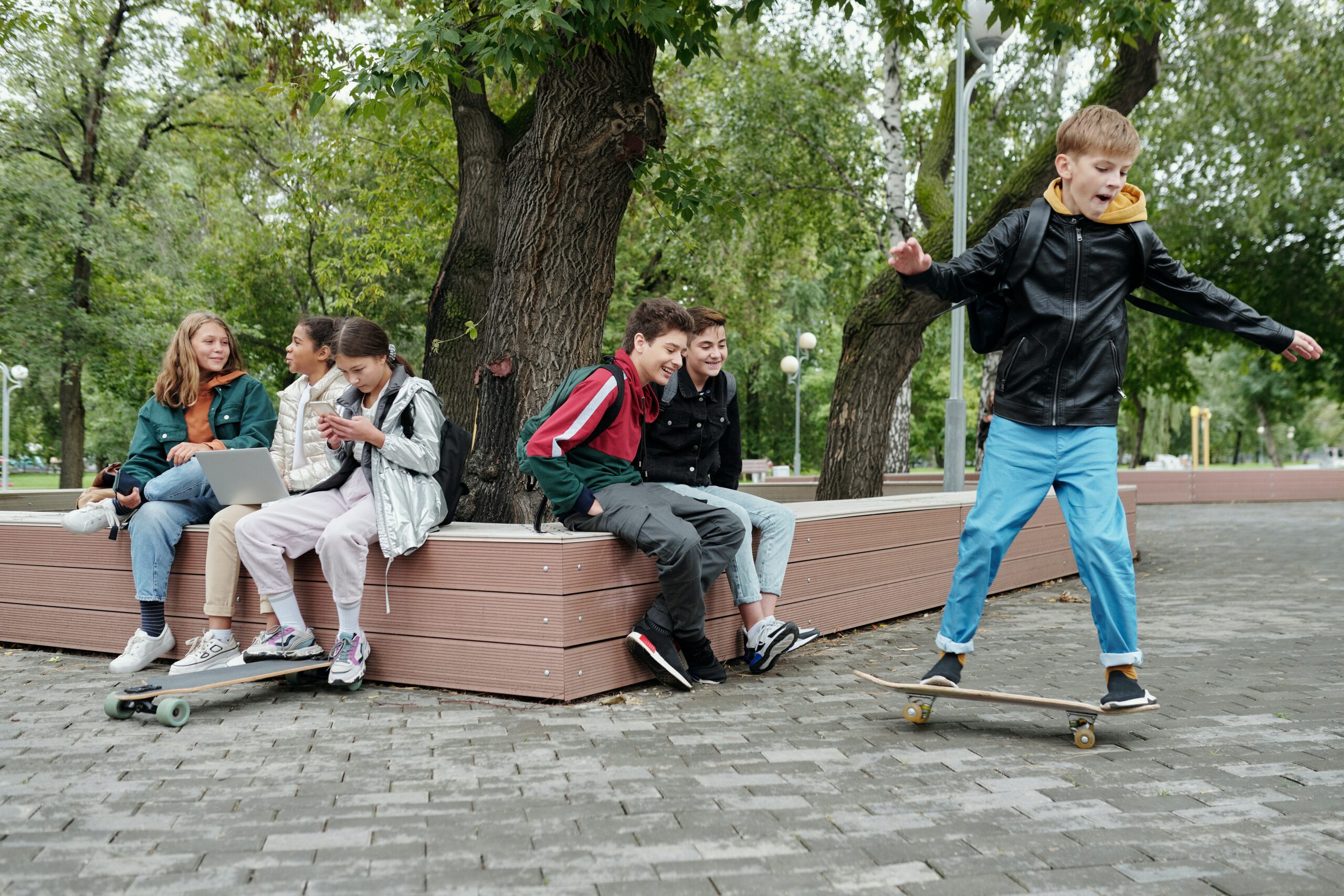 Several kids with skateboards in a park.